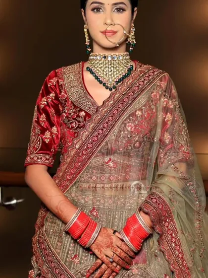 A full-length view of the bride, showcasing the beautiful contrast of the green dupatta with the red velvet blouse.
