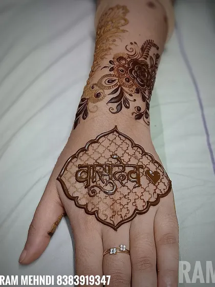 For a spiritual touch, this groom chose the name 'Vasudev' in a classic Devanagari script. The name is set within a traditional frame with a delicate net pattern.