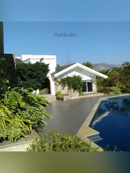 A classic villa poolside surrounded by lush greenery. We used a mix of tropical plants and flowering shrubs to create a private, verdant setting for this beautiful pool and patio area.