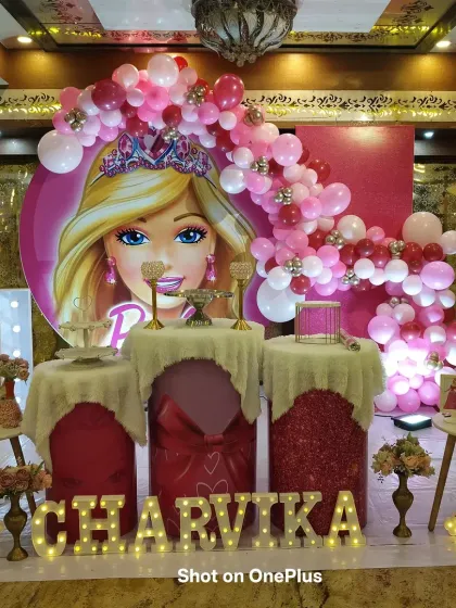 The complete Barbie-themed stage for Charvika's first birthday. The setup includes a light-up number '1', themed dessert pedestals, and small rainbow lights for an extra touch of magic.