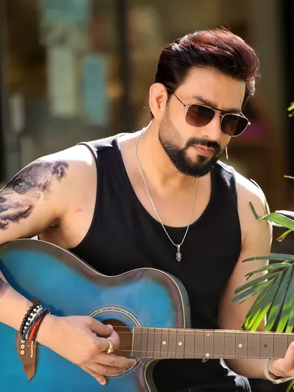 Actor Aadesh Chaudhary in a rugged, casual look. This outdoor shot with a guitar shows a different, more relaxed character type, adding another layer to his portfolio.