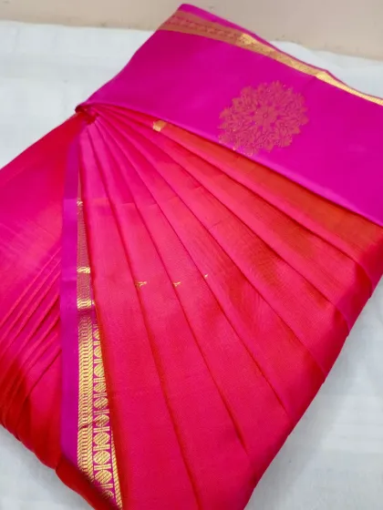 A bright pink silk saree with a simple gold border. Even simpler sarees look exceptionally elegant with perfectly set pleats.