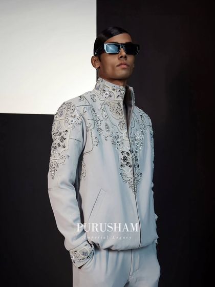 This is my take on a modern bomber jacket. Crafted in a light grey fabric, it is covered in intricate, swirling embroidery, transforming a casual silhouette into a piece of wearable art.