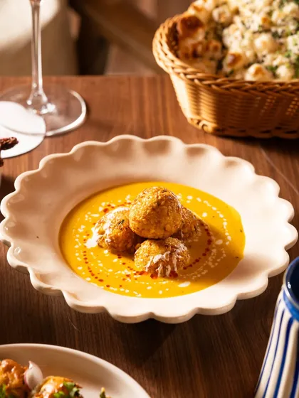 A modern take on dahi vada or a similar dish, served in a beautiful scalloped bowl. This shows how traditional food can be presented elegantly.