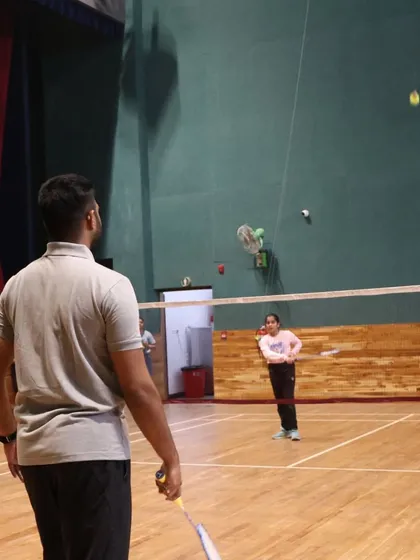 A coach demonstrating the correct form for a shot during a special coaching camp at Crimson Anisha Global School.