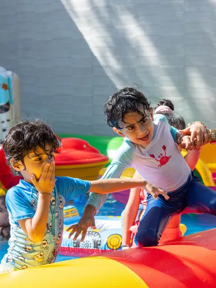 The excitement is real. This candid shot shows two boys having a playful time on the inflatable obstacle in the pool during our Splash Fiesta weekend.