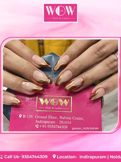 A modern and edgy take on the French manicure. These almond-shaped extensions feature a nude base with a deep red and metallic gold abstract tip, combining color and texture beautifully.