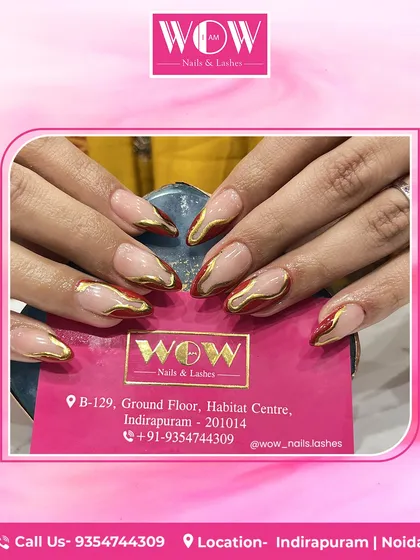 A modern and edgy take on the French manicure. These almond-shaped extensions feature a nude base with a deep red and metallic gold abstract tip, combining color and texture beautifully.