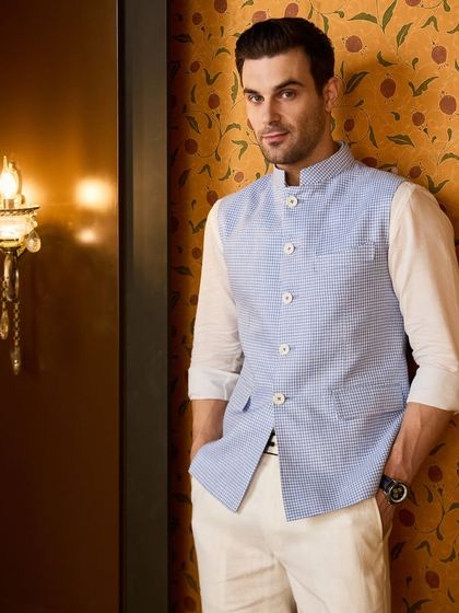 A confident pose showcasing the tailored fit of the pastel blue waistcoat. It's an effortlessly cool look for any wedding guest.