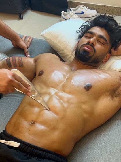 Another angle of the Graston technique being applied to a professional athlete's chest and abs, showcasing the focus and precision of the therapy.