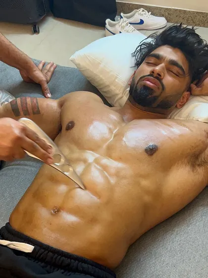 Another angle of the Graston technique being applied to a professional athlete's chest and abs, showcasing the focus and precision of the therapy.