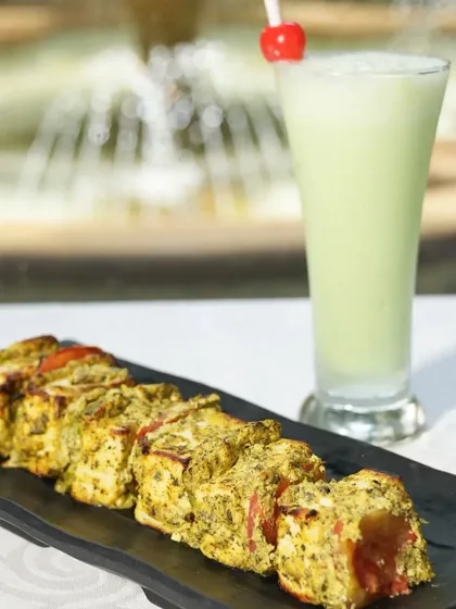 A zesty and refreshing starter, the Paneer Minty Lemon Tikka is marinated in a vibrant blend of mint, lemon, and spices. It's grilled to give it a smoky flavor that complements the fresh herbs.