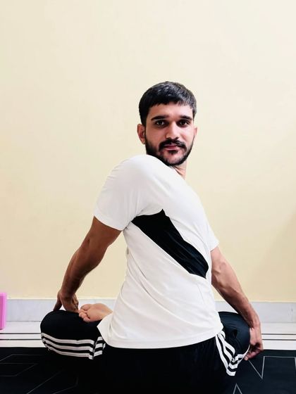 A seated spinal twist, Ardha Matsyendrasana, which detoxifies the organs and increases spinal mobility.