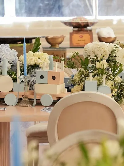 A wider view of the toy train centerpiece amidst the floral arrangements.