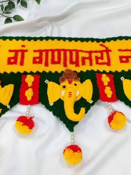 This is my most popular Ganpati toran, a design that brings blessings to your doorstep. I carefully crochet each element, from the "ॐ गं गणपतये नमः" text to the bright yellow Ganpati faces and colorful pom-poms, using durable 4-ply acrylic yarn.