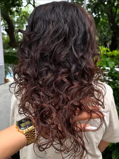 Curly and proud. I gave her curls a new life with a fresh cut, including a fringe, and subtle reddish-brown highlights to define the texture. Embracing your natural curls is always a good idea.
