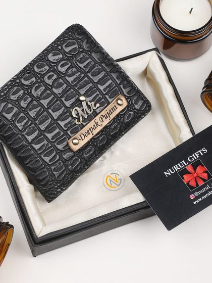 A classic black crocodile leather wallet personalized with a 'Mr.' charm and nameplate.