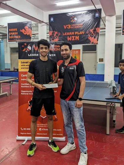 Awarding a prize to a competitor at our academy's open tournament. The event was a success, bringing together numerous players for a day of intense table tennis.