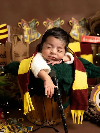 Even wizards need their rest. This adorable shot captures our baby Harry Potter dozing off in a bucket, his magic wand resting by his side.