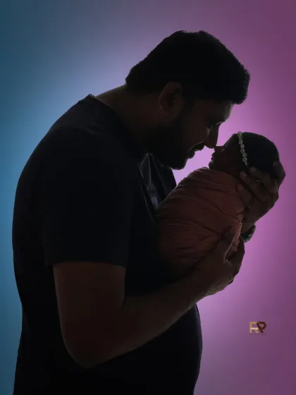 Sometimes, the most powerful portraits are the simplest. This silhouette shot of a father and his newborn uses light and shadow to create a dramatic and intimate image, focusing on the tender bond and the beginning of a lifelong connection.