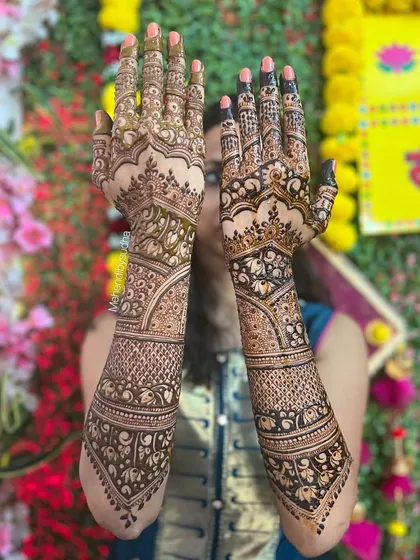 A gorgeous bridal design for Pooja, with a floral background that makes the rich, dark henna pop. The design uses negative space beautifully to highlight the main motifs.