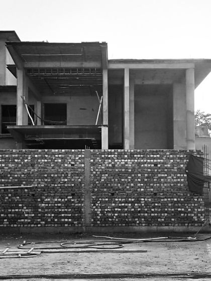 The front view of a building's structural shell, with exposed brickwork on the lower level and open floors above.