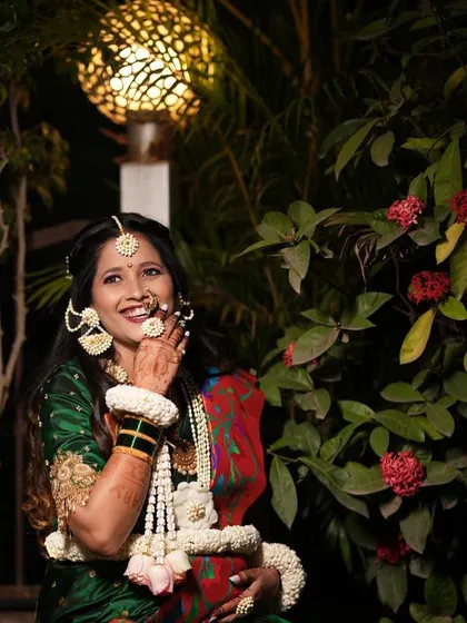 A happy mom-to-be wearing our traditional white floral jewellery for her baby shower. The set includes a long necklace, earrings, and hair accessories.