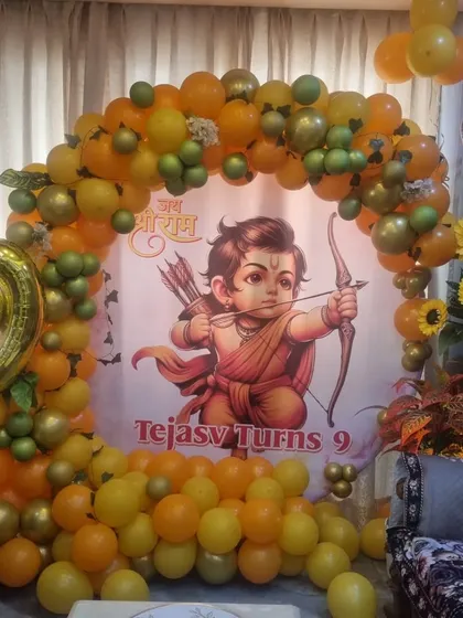 A unique birthday celebration at home with a 'Jai Shri Ram' theme. This setup includes a custom banner of Lord Ram, surrounded by a full balloon arch in shades of orange and yellow, perfect for a traditional touch.