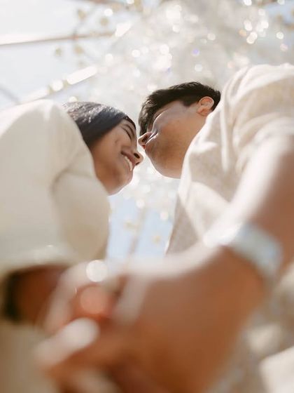 A fun, low angle shot looking up at the couple against a glass ceiling. We love finding creative perspectives that make your couple portraits unique and dynamic.