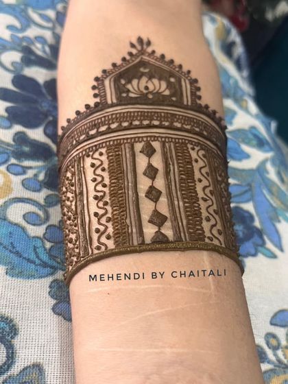 A traditional armband or 'bajuband' style mehendi for a sider. This design features a lotus motif and is a great option for those who want mehendi just on their arms.