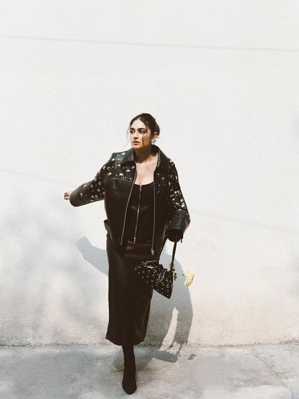 A dynamic shot of Kavya Trehan in motion. The play of light and shadow against the white wall creates a high-impact, minimalist fashion photograph.