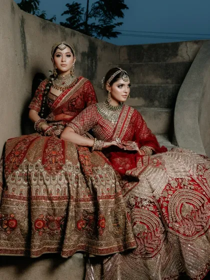 Two of my brides in stunning, coordinated red lehengas. This shot showcases my ability to create unique yet complementary looks for campaign photoshoots.