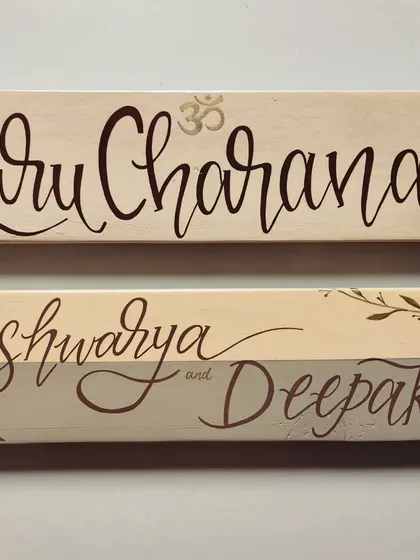 Simplicity and elegance in a set of two name plaques. Created with soft, minimal tones and delicate leafy details, these pieces for "Guru Charana" and "Aishwarya and Deepak" bring a sense of calm.