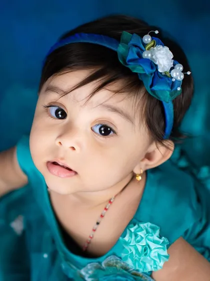 A sweet close-up of our little mermaid. Her bright eyes and the detailed headband complete this adorable under-the-sea look.