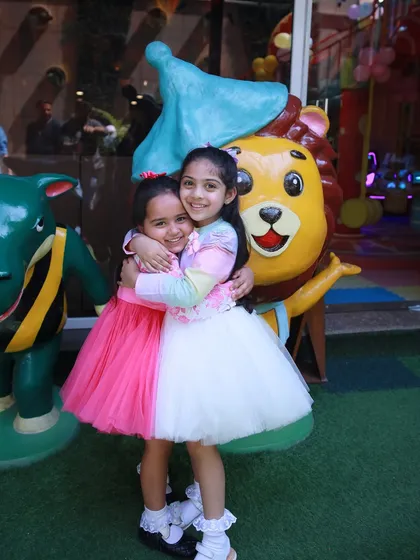 A warm hug between friends next to one of our friendly character statues.