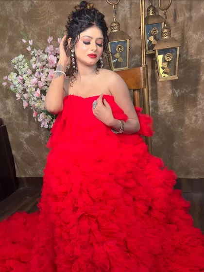 A studio shot of the red ruffled gown, showing its texture and volume. The off-shoulder design is elegant and perfect for showing off your jewellery.