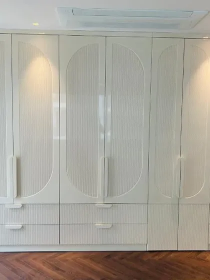 This version of our custom wardrobe features a fluted texture within the CNC-milled patterns, adding subtle detail and depth to the high-gloss PU shutters.