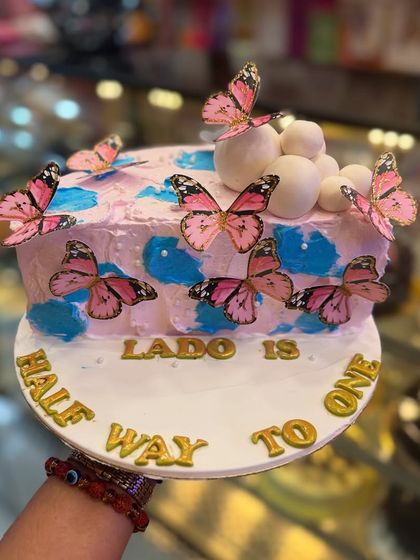 A beautiful butterfly-themed cake for a six-month birthday celebration. The delicate pink butterflies and soft colors make it a perfect choice for celebrating a half-birthday milestone.
