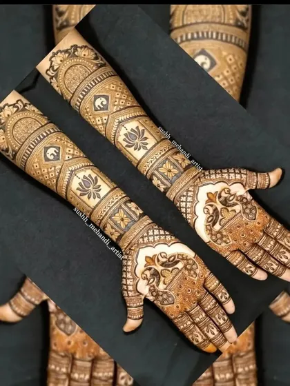 A creative shot of a full bridal mehandi. The design includes bands of elephants, lotus flowers, and peacocks on the palms.