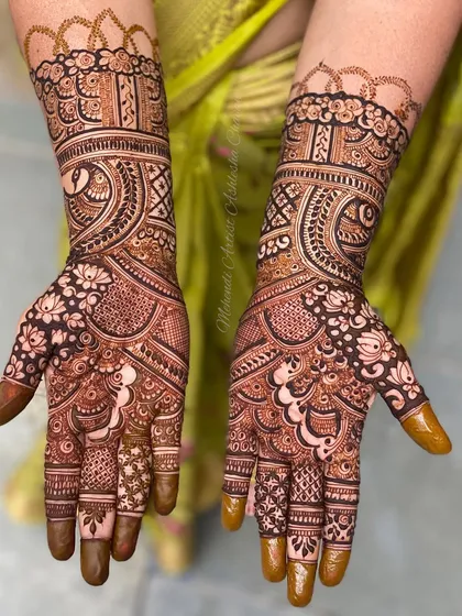 A classic Indian mehendi design with dense, intricate patterns. The use of negative space makes the peacock and floral motifs pop.