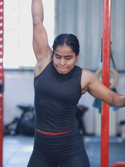 An athlete powers through a dumbbell snatch during the competition, showcasing explosive strength and control.