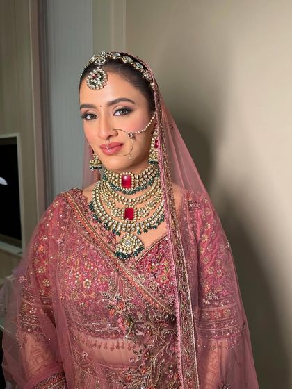 A close-up of a modern pink bridal look, blending tradition with a touch of contemporary style. The focus is on the eyes and the flawless skin.