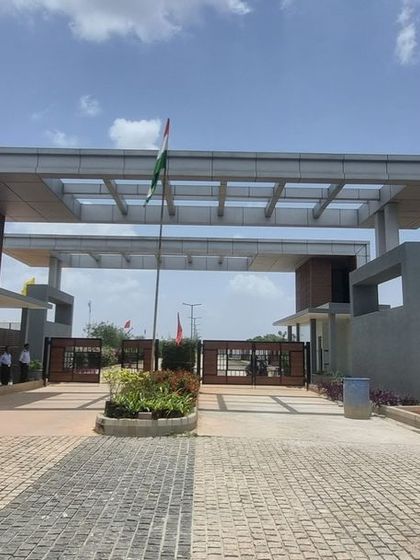 The completed entrance gate at Aamby City, Hoskote, featuring modern architectural design and initial planting.