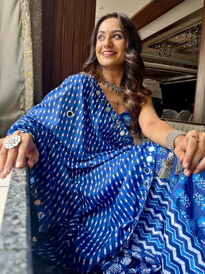 A confident and happy Navratri look. The silver jewelry and blue tones in her makeup create a cohesive and stylish festive appearance.