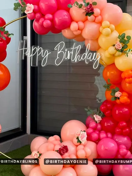A close-up of the sunset ring arch, highlighting the neon "Happy Birthday" sign and the beautiful blend of colors.