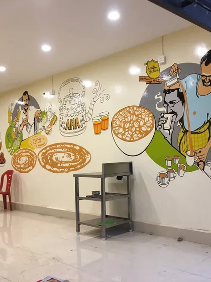 For this restaurant, we painted a full-wall illustrative mural capturing the essence of South Indian tiffin culture. The artwork features scenes of chai being poured, dosas being made, and customers enjoying their food, creating a warm and inviting atmosphere for diners.