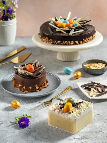 An assortment of Easter-themed chocolate cakes and pastries, decorated with chocolate eggs and shavings for a festive menu shoot.