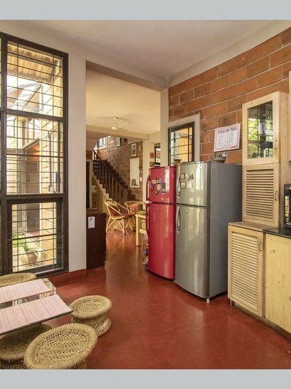 The dining and kitchen area, showing the open-plan layout and the large windows that connect the space to the outdoors.