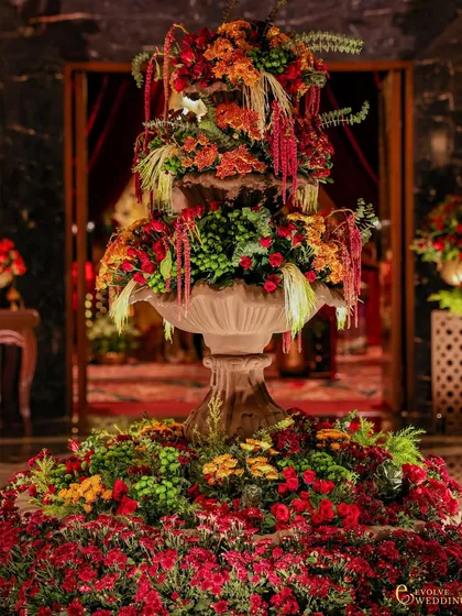 I believe in the power of abundant beauty. This towering floral fountain, crafted from a cascade of crimson roses, carnations, and other vibrant blooms, served as a breathtaking centerpiece, embodying my philosophy of 'zeenat' or beauty that enriches the soul.