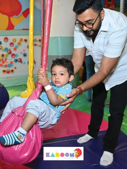 A helping hand from dad makes the first time on the swing a little less scary and a lot more fun.